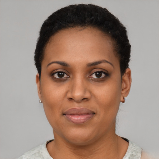 Joyful black young-adult female with short  black hair and brown eyes