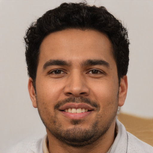 Joyful latino young-adult male with short  brown hair and brown eyes