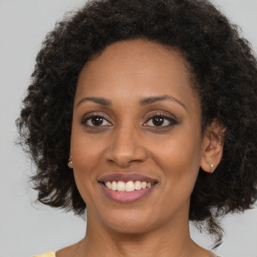 Joyful black young-adult female with medium  brown hair and brown eyes