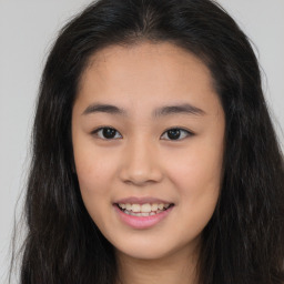 Joyful asian young-adult female with long  brown hair and brown eyes