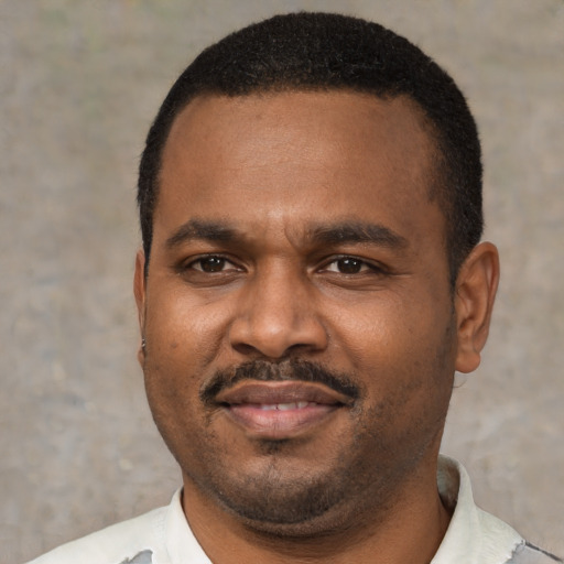 Joyful black young-adult male with short  black hair and brown eyes