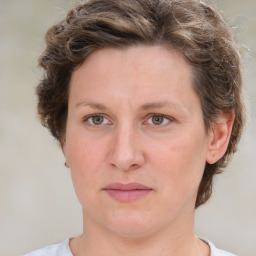 Joyful white young-adult female with medium  brown hair and green eyes