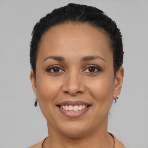 Joyful latino young-adult female with short  black hair and brown eyes