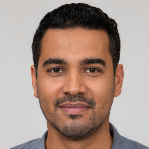 Joyful latino young-adult male with short  black hair and brown eyes