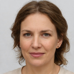 Joyful white adult female with medium  brown hair and green eyes