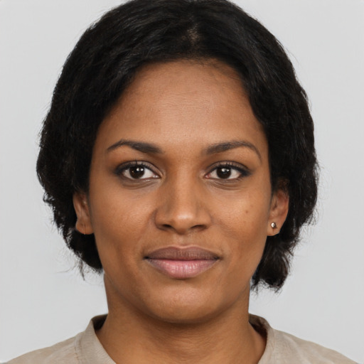 Joyful black young-adult female with short  brown hair and brown eyes