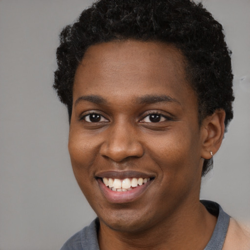 Joyful black young-adult female with short  brown hair and brown eyes