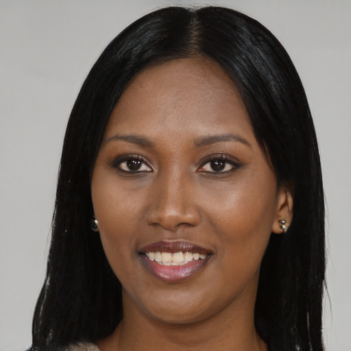 Joyful black young-adult female with long  black hair and brown eyes