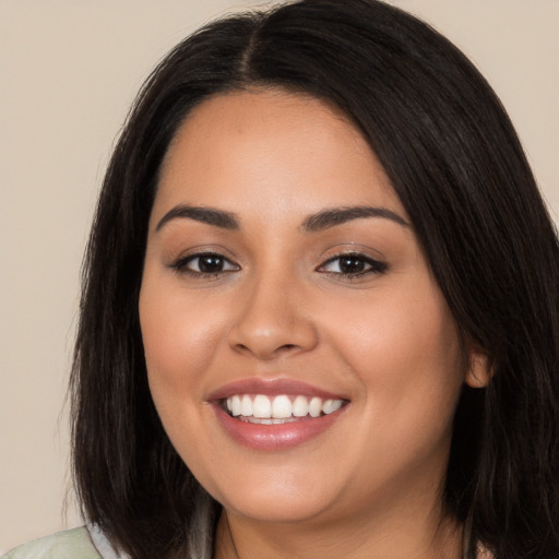 Joyful latino young-adult female with long  brown hair and brown eyes