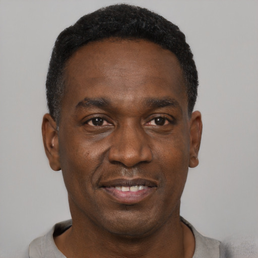 Joyful black adult male with short  black hair and brown eyes