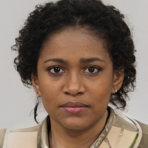 Joyful black young-adult female with short  brown hair and brown eyes