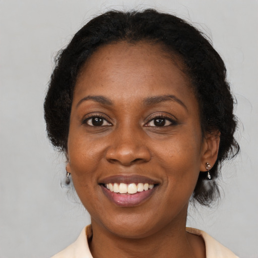 Joyful black adult female with medium  brown hair and brown eyes