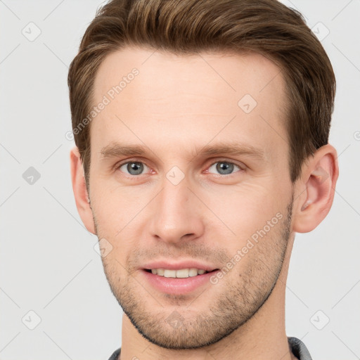 Joyful white young-adult male with short  brown hair and grey eyes