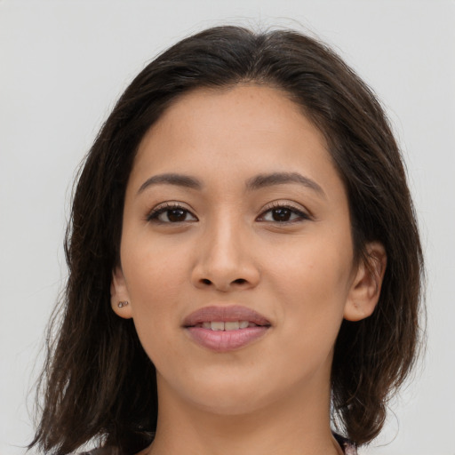 Joyful latino young-adult female with medium  brown hair and brown eyes