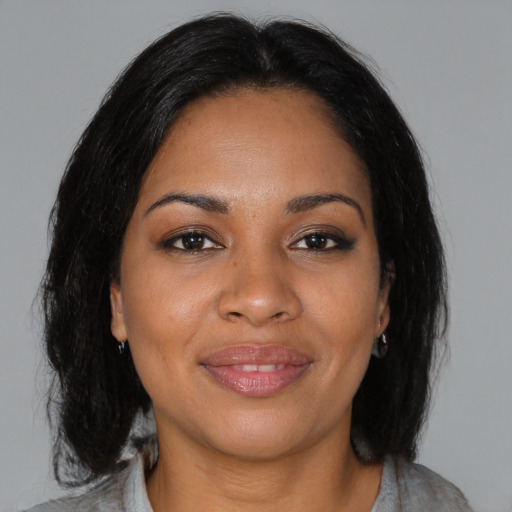 Joyful black young-adult female with medium  brown hair and brown eyes