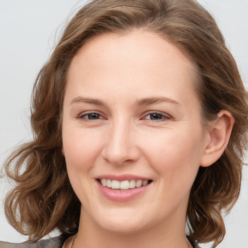 Joyful white young-adult female with medium  brown hair and blue eyes