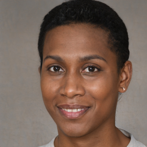 Joyful black young-adult female with short  black hair and brown eyes