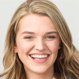 Joyful white young-adult female with long  brown hair and green eyes