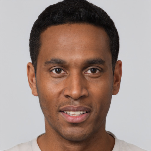 Joyful black young-adult male with short  black hair and brown eyes