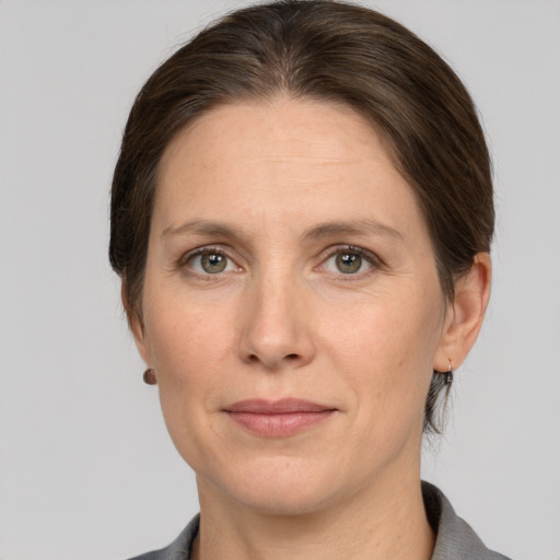 Joyful white adult female with medium  brown hair and grey eyes