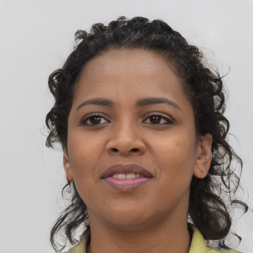 Joyful black young-adult female with long  brown hair and brown eyes