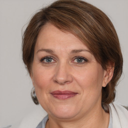 Joyful white adult female with medium  brown hair and grey eyes