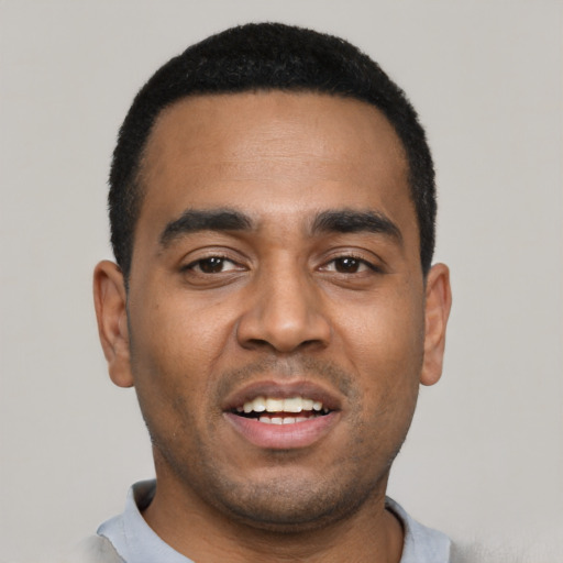 Joyful black young-adult male with short  black hair and brown eyes