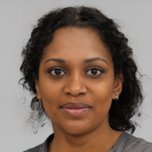 Joyful black young-adult female with medium  brown hair and brown eyes