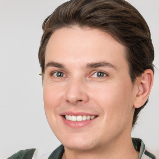 Joyful white young-adult male with short  brown hair and grey eyes