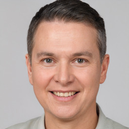 Joyful white adult male with short  brown hair and brown eyes