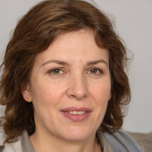 Joyful white adult female with medium  brown hair and green eyes