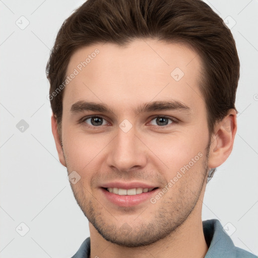 Joyful white young-adult male with short  brown hair and grey eyes