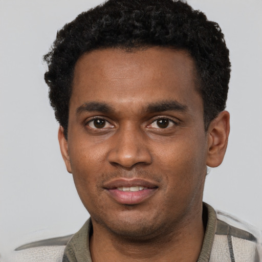 Joyful black young-adult male with short  black hair and brown eyes