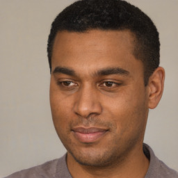 Joyful black young-adult male with short  black hair and brown eyes