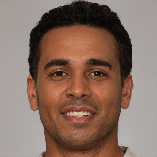 Joyful black young-adult male with short  black hair and brown eyes