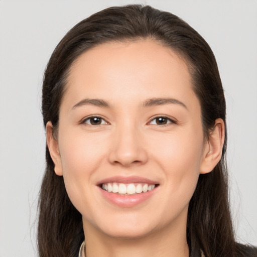 Joyful white young-adult female with long  brown hair and brown eyes