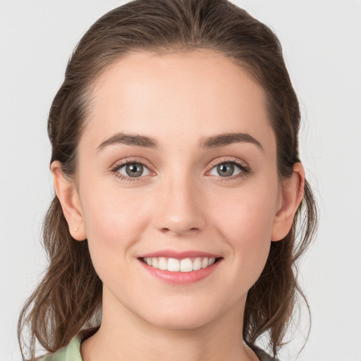 Joyful white young-adult female with medium  brown hair and green eyes