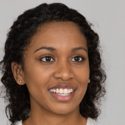 Joyful black young-adult female with long  brown hair and brown eyes