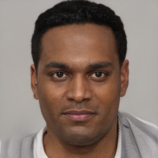Joyful black young-adult male with short  black hair and brown eyes