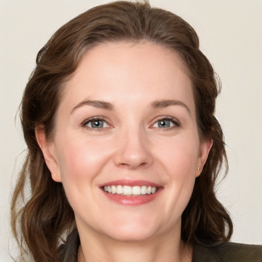 Joyful white young-adult female with medium  brown hair and grey eyes