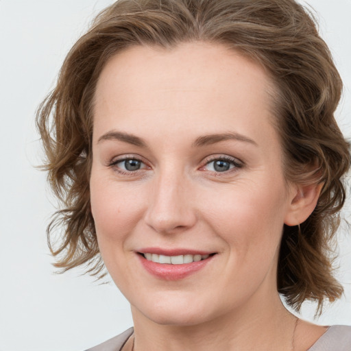 Joyful white young-adult female with medium  brown hair and blue eyes