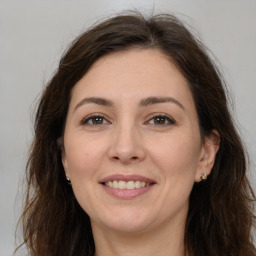 Joyful white adult female with long  brown hair and brown eyes