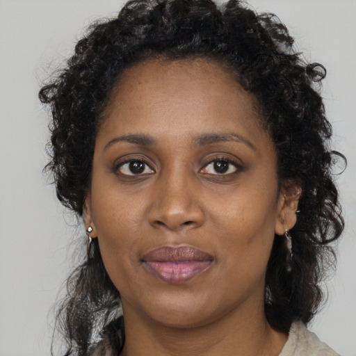Joyful black young-adult female with long  brown hair and brown eyes