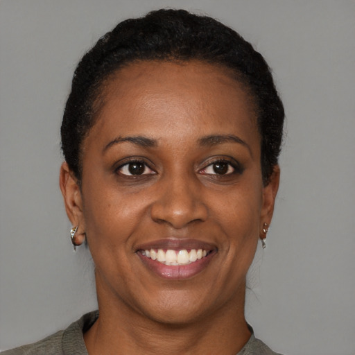 Joyful black adult female with short  black hair and brown eyes