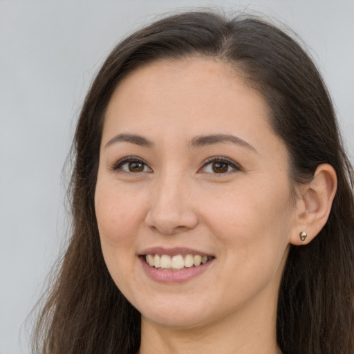 Joyful white young-adult female with long  brown hair and brown eyes