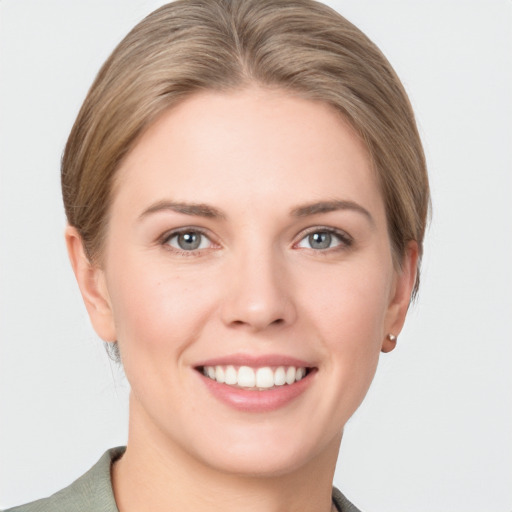 Joyful white young-adult female with short  brown hair and grey eyes