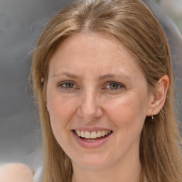 Joyful white adult female with long  brown hair and grey eyes