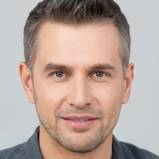 Joyful white adult male with short  brown hair and brown eyes