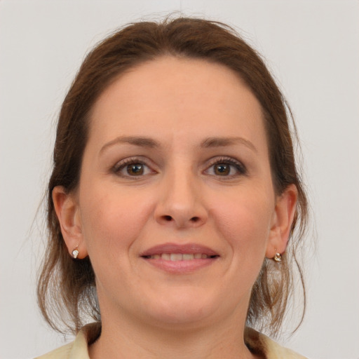 Joyful white young-adult female with medium  brown hair and grey eyes