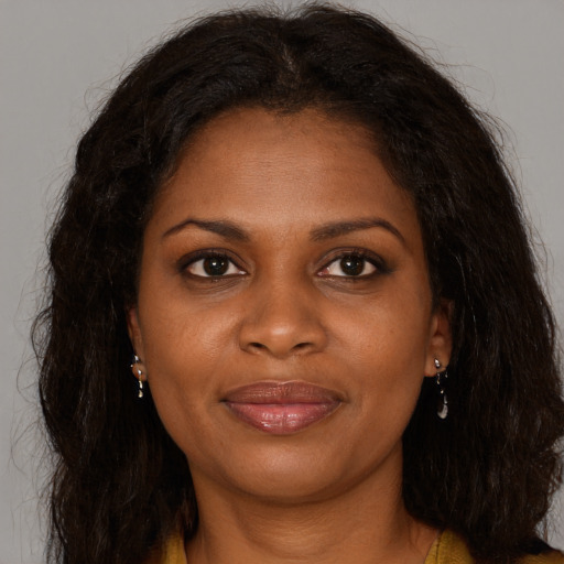 Joyful black young-adult female with long  brown hair and brown eyes